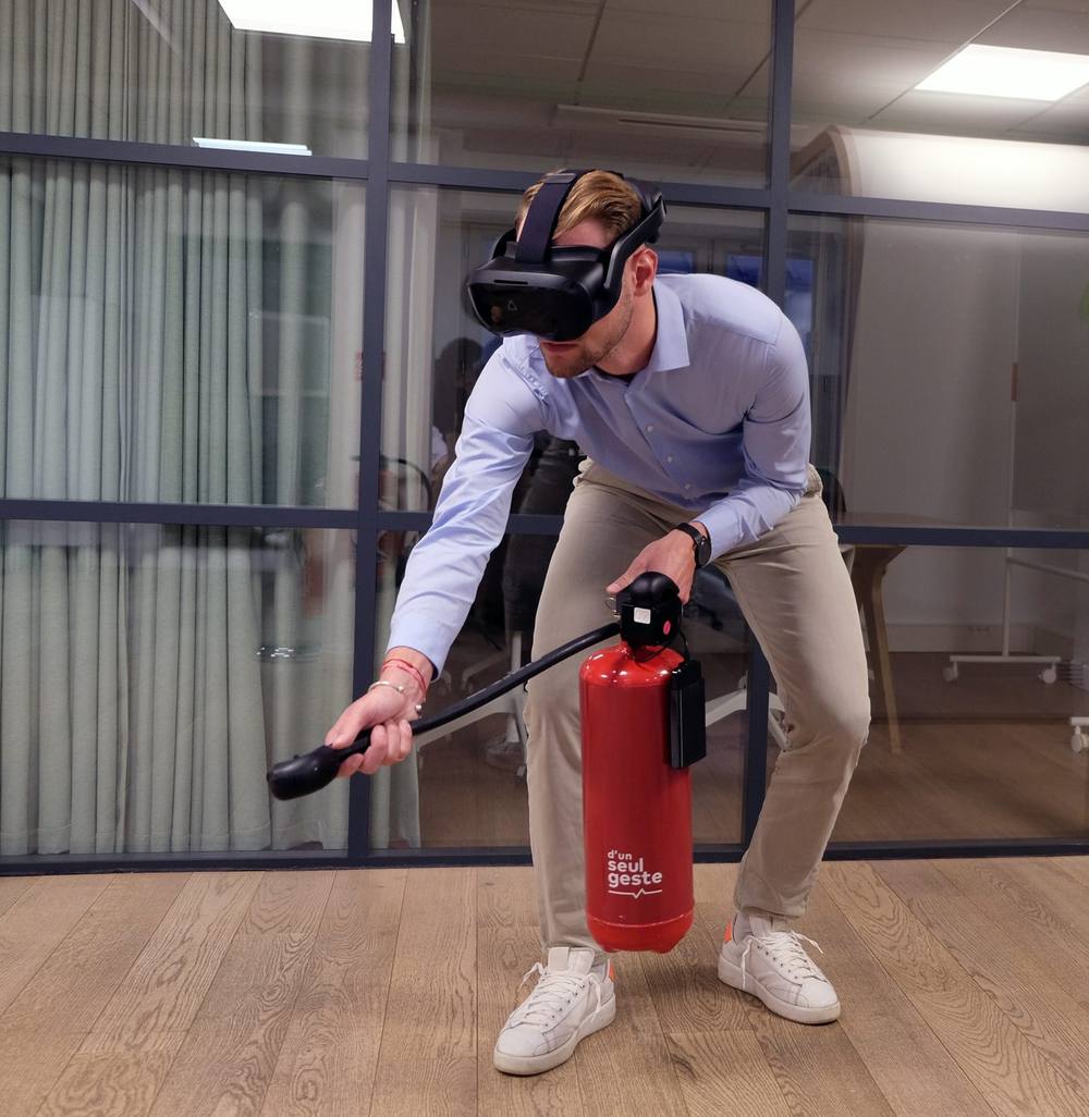 Participant utilisant l extincteur connecté d un seul geste pendant une session de formation incendie en réalité virtuelle